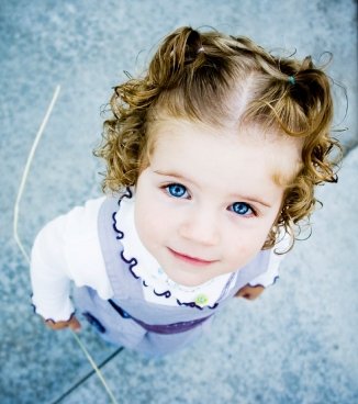 Little Girl With Curly Hair And Pigtails